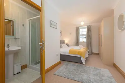 a bedroom with a bed and a sink and a shower at Sand Dunes 6 The Manor in St Ives