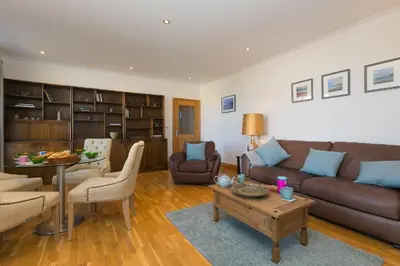 a living room with a couch and a table at Sand Dunes 6 The Manor in St Ives