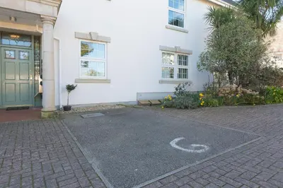 a house with a driveway in front of a building at Sand Dunes 6 The Manor in St Ives