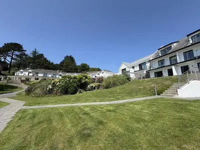 a grassy hill next to a apartment building at Oystercatcher - Mount Brioni in Downderry