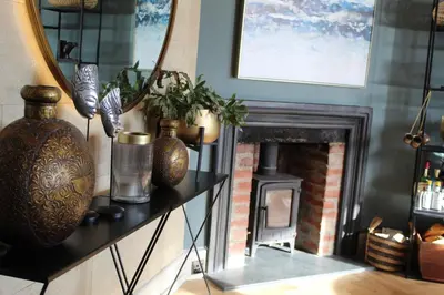 a living room with a fireplace and a mirror at Oystercatcher - Mount Brioni in Downderry