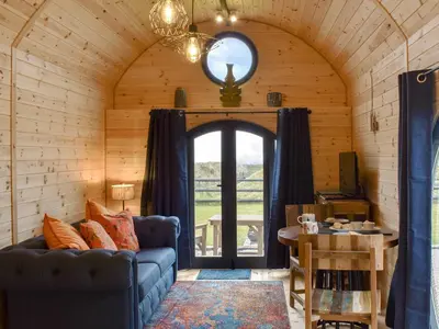 a living room with a couch and a table at Krowji Klys in Boscastle