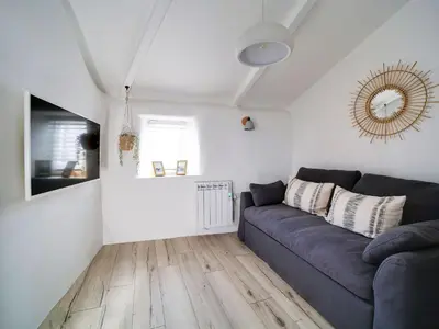 a living room with a couch and a mirror at Bell Cottage in Saint Teath