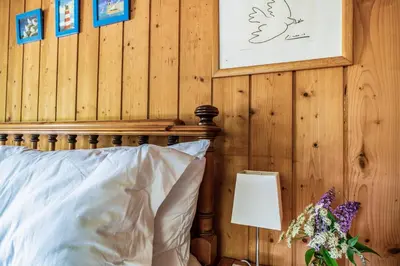 a bedroom with a bed and a wooden wall at Scandinavian Style Lodge in Rock in Wadebridge