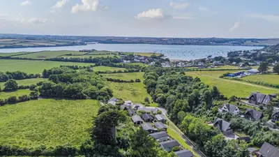an aerial view of a village with a lake at Scandinavian Style Lodge in Rock in Wadebridge