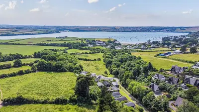an aerial view of a village with a lake at Scandinavian Style Lodge in Rock in Wadebridge