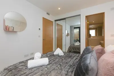 a living room with a bed and a mirror at Monowai Heights in St Ives