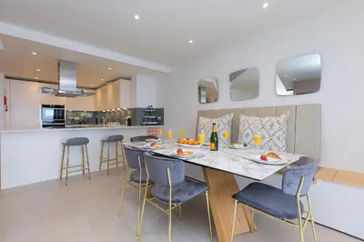 a dining room and kitchen with a table and chairs at Monowai Heights in St Ives