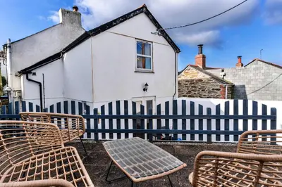 a fence with chairs and a table in front of a house at Finest Retreats - Salvay in Porthleven