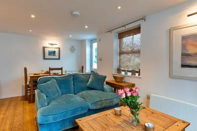 a living room with a blue couch and a table at Finest Retreats - Salvay in Porthleven