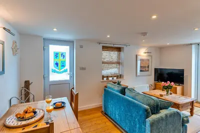 a living room with a blue couch and a table at Finest Retreats - Salvay in Porthleven