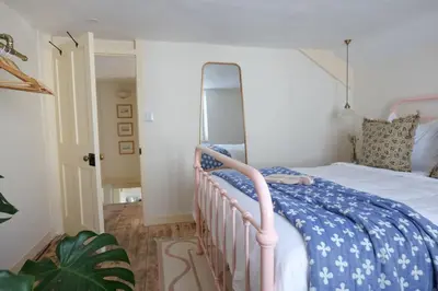 a bedroom with a bed with a blue and white comforter at Wheelwright House in Bodmin