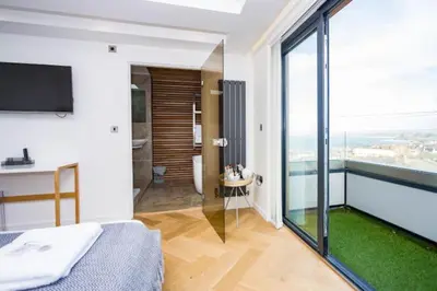 a bedroom with a bed and a large window at George24 - spectacular, 5 minutes to the beach in Newquay