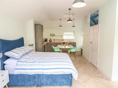 a bedroom with a bed and a table with chairs at Byghan Thornton in Redruth