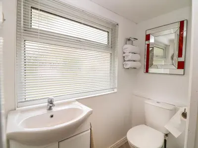 a bathroom with a sink and a toilet and a window at Byghan Thornton in Redruth
