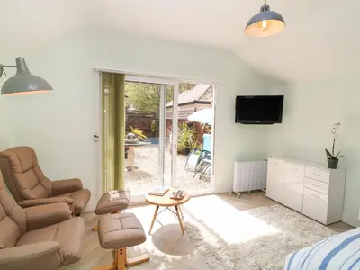 a living room with a couch and a chair and a tv at Byghan Thornton in Redruth