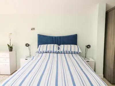 a bed with a blue headboard in a bedroom at Byghan Thornton in Redruth