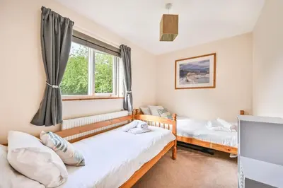 two beds in a room with a window at 3 bed Lodge with EV point in Truro