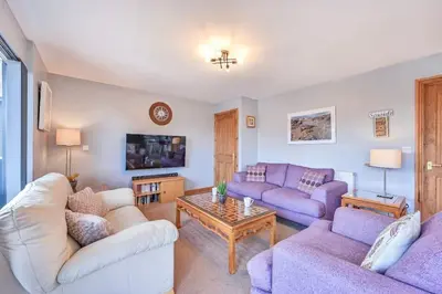 a living room with two couches and a table at 3 bed Lodge with EV point in Truro