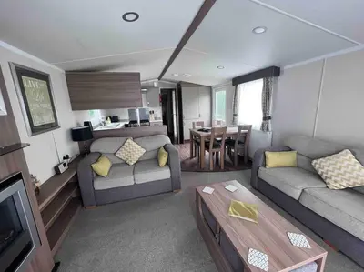 a living room with a couch and a table at Polladras Holiday Park in Helston