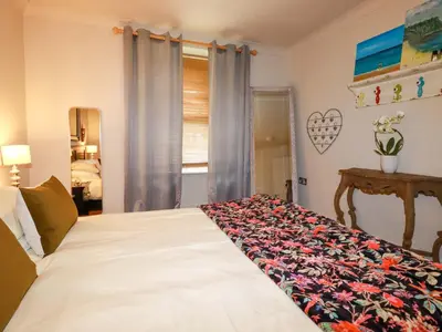 a bedroom with a bed with a floral bedspread at Sea View in St Austell