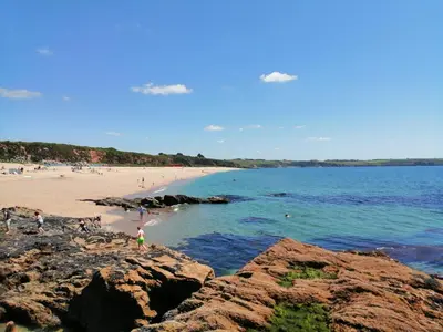 a beach with people on the sand and the water at Sea View in St Austell