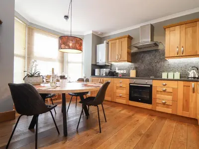 a kitchen with a dining room table and chairs at Hillcroft in St Austell