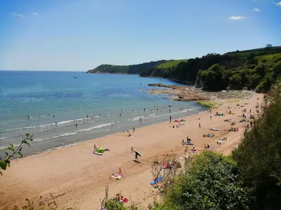 a group of people on a beach near the ocean at Hillcroft in St Austell