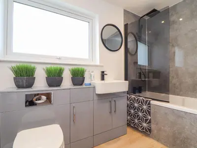 a bathroom with a sink and a toilet and a window at Pickney House in Looe