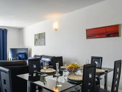 a dining room with a table and chairs with wine glasses at Apartment 15 Harvest Moon in Newquay
