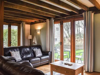 a living room with a leather couch and a table at Chy An Dour in Davidstow