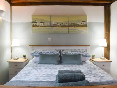a bedroom with a large bed with two lamps at Chy An Dour in Davidstow
