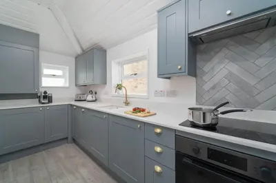 a kitchen with blue cabinets and a sink at The Lost Lobster in St Ives