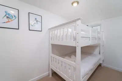 a white bunk bed in a white room at The Lost Lobster in St Ives