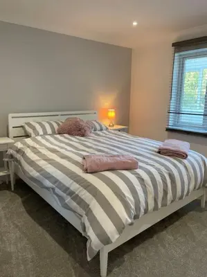a bedroom with a large bed with two pillows on it at Sunny Corner - lovely 2 bedroom appt in Redruth