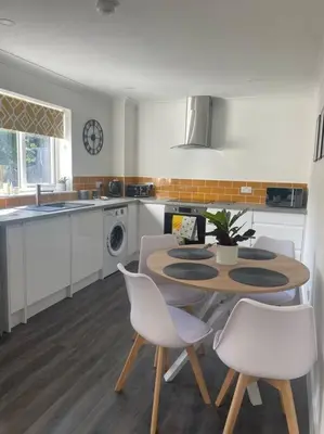 a kitchen with a table and chairs in a kitchen at Sunny Corner - lovely 2 bedroom appt in Redruth