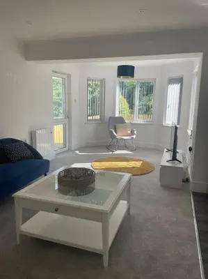 a living room with a couch and a table at Sunny Corner - lovely 2 bedroom appt in Redruth