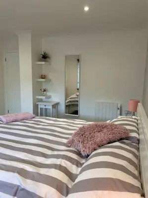 a bedroom with a large bed with a pillow on it at Sunny Corner - lovely 2 bedroom appt in Redruth