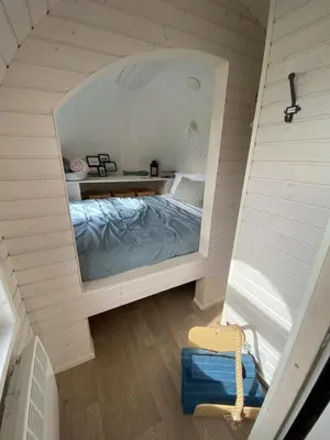 a bedroom with a bed and a large mirror at The Pilchard - Lydcott Glamping Cornwall, sea view in East Looe