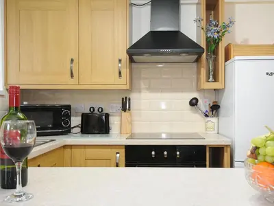 a kitchen with a counter with a glass of wine at Small Barn in Liskeard