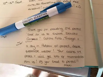 a pen sitting on top of a paper with handwriting at Prosecco - Lydcott Glamping Cornwall, sea views in East Looe