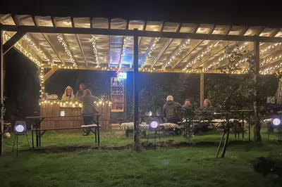 a group of people standing under a pavilion at night at Prosecco - Lydcott Glamping Cornwall, sea views in East Looe