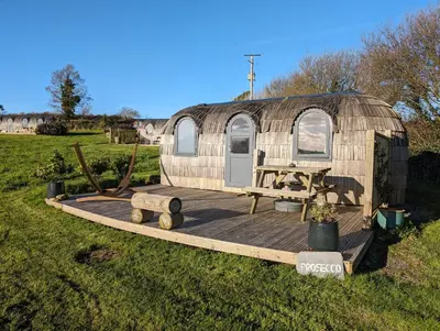 a yurt with a wooden deck in a field at Prosecco - Lydcott Glamping Cornwall, sea views in East Looe