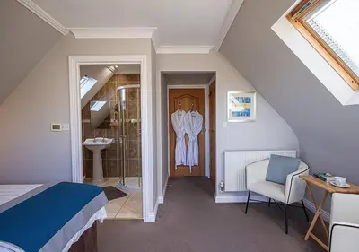 a bedroom with a bed and a bathroom with a shower at Orchard House Wadebridge Self Catering in Wadebridge