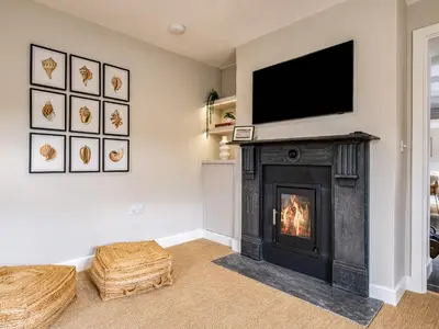 a living room with a fireplace with a flat screen tv at Mermaid Cottage in Port Isaac