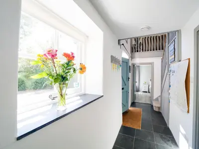 a vase of flowers on a window sill in a hallway at Stone Barn in Camelford