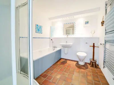a bathroom with a tub and a toilet and a sink at Stone Barn in Camelford