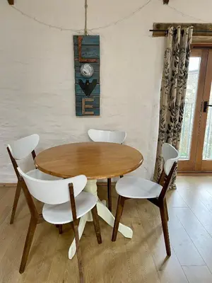 a wooden table and four chairs in a room at Rosehip Barn in Launceston