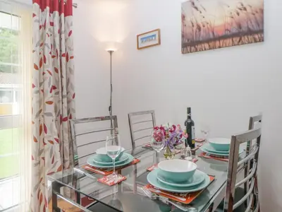 a dining room with a glass table and chairs at Sycamores in Liskeard