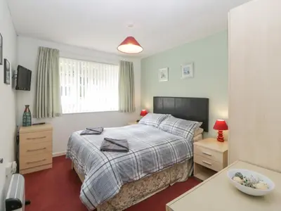 a small bedroom with a bed and a window at Sycamores in Liskeard